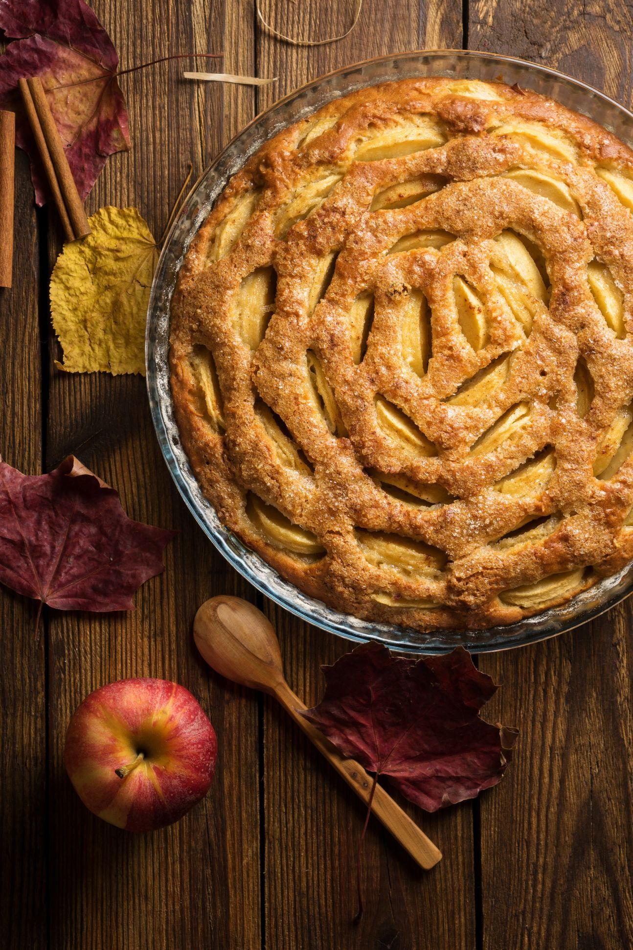 Runder, gedeckter Apfelkuchen, dekoriert mit ganzem Apfel.