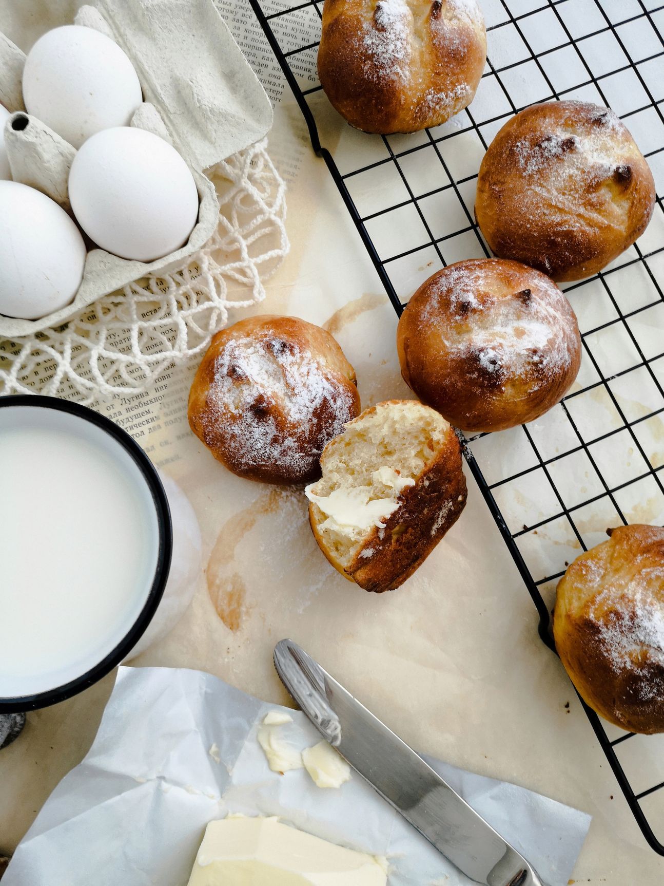 Mehrere Brioches, zum Teil aufgeschnitten und einige Eier als Deko.