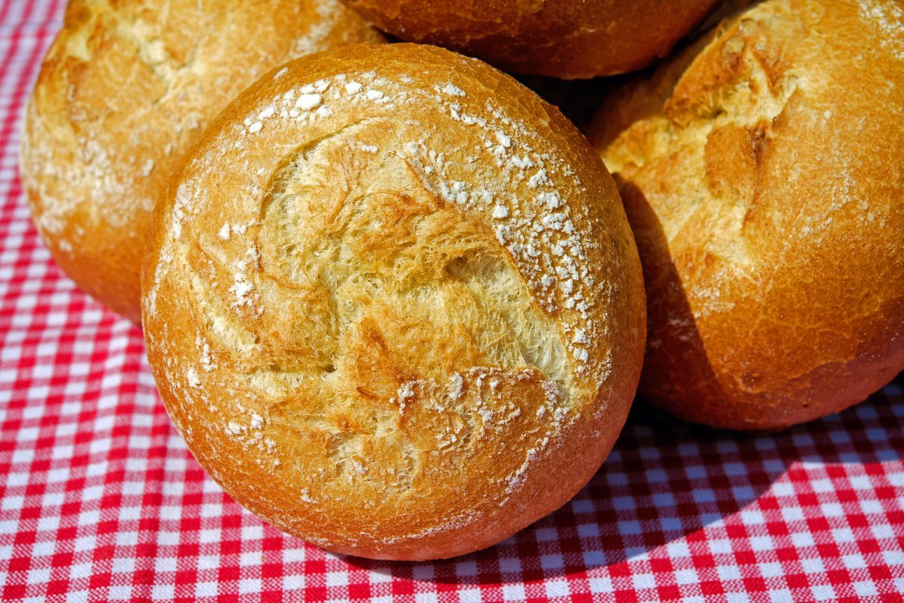 3 runde Brötchen auf einem rot-weiß-karierten Tuch.