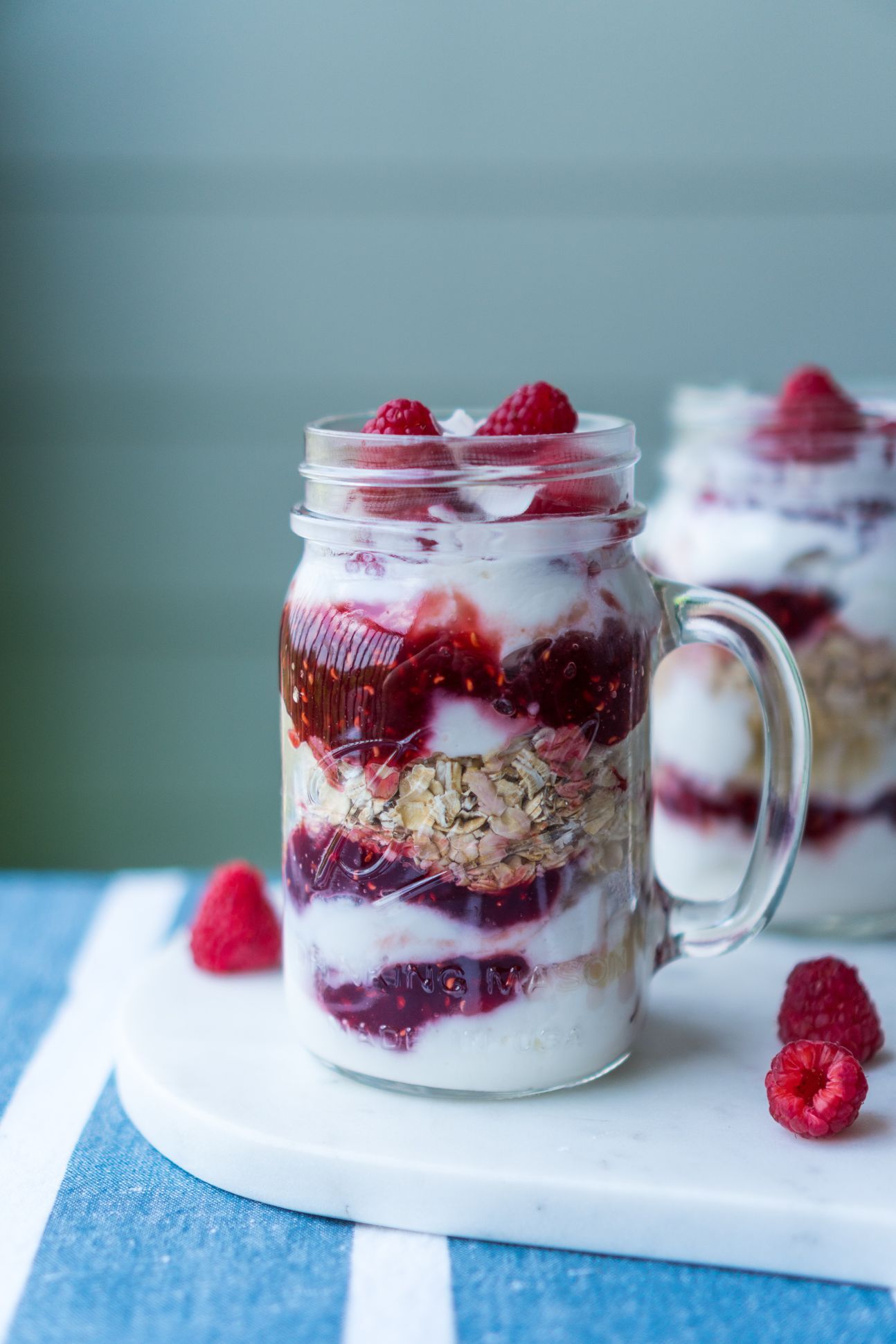 Dessert im Glas und mit Himbeeren dekoriert.