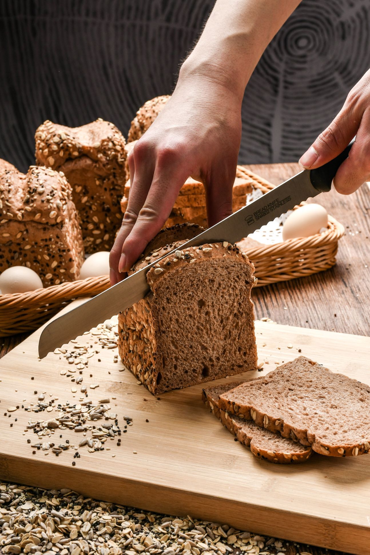 Aufgeschnittenes, dunkles Brot auf einem Brett.