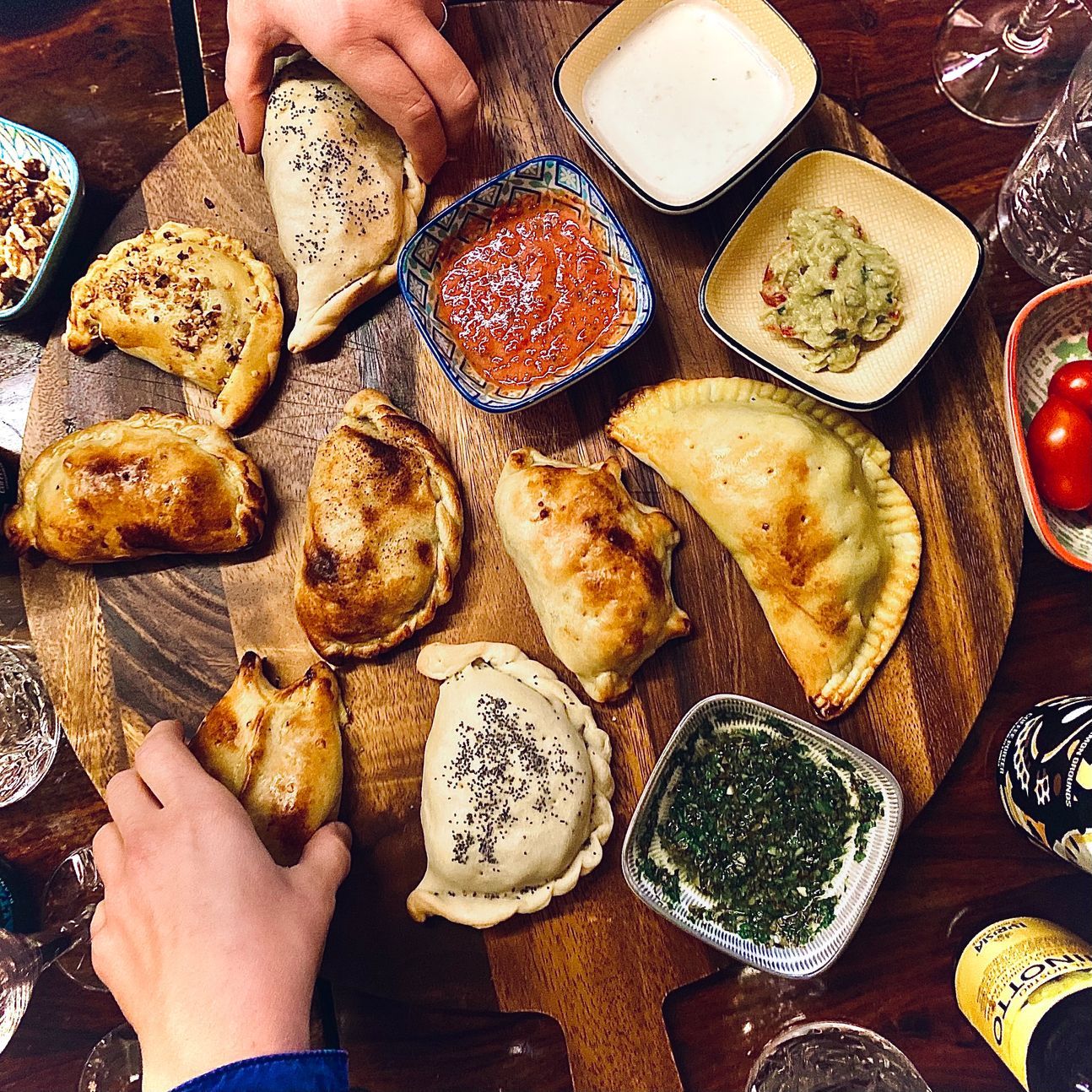 Verschiedene Empanadas mit verschiedenen Zutaten in Schälchen.