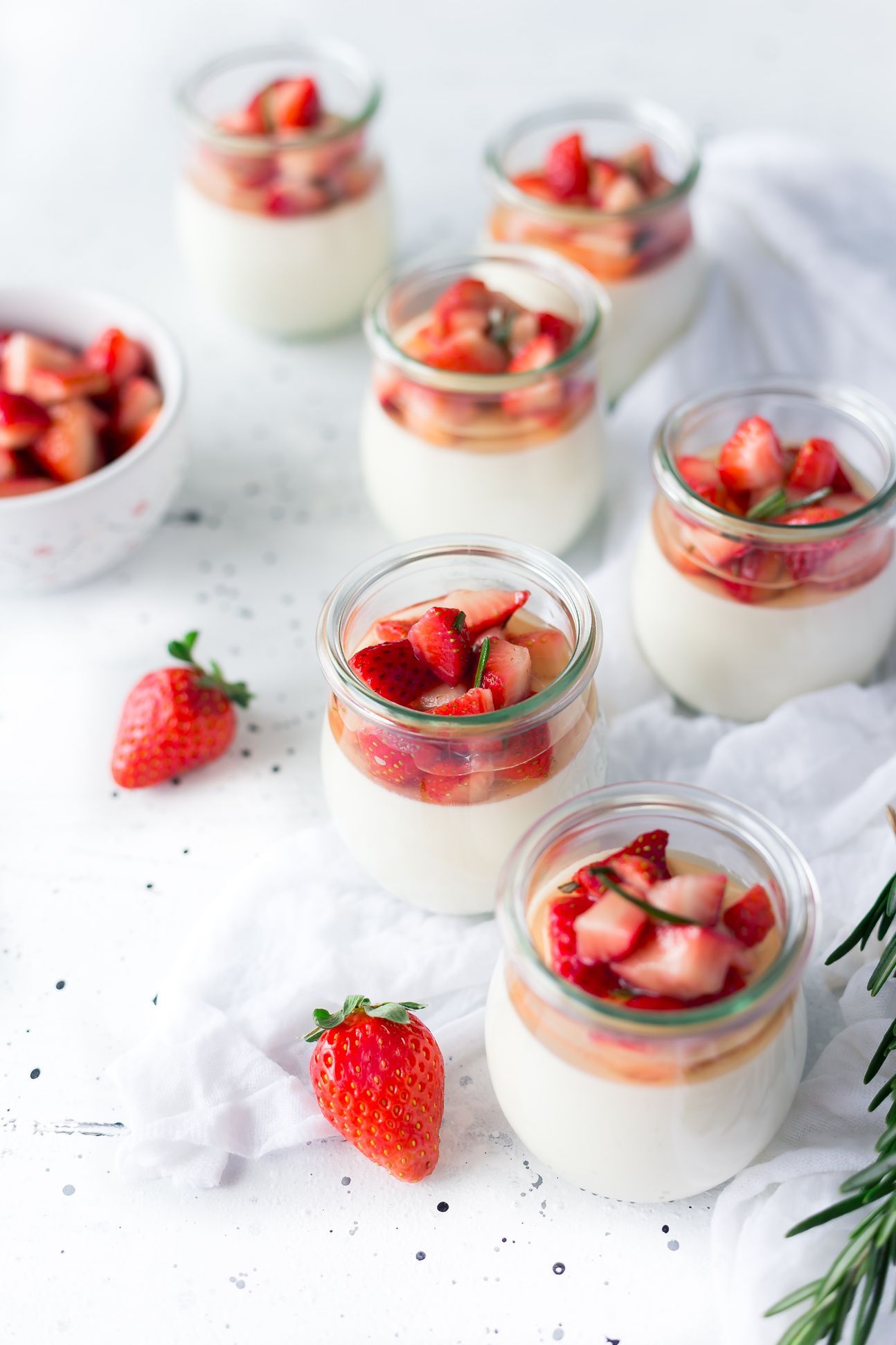 Mehrere Gläschen, gefüllt mit Quark und Erdbeeren.