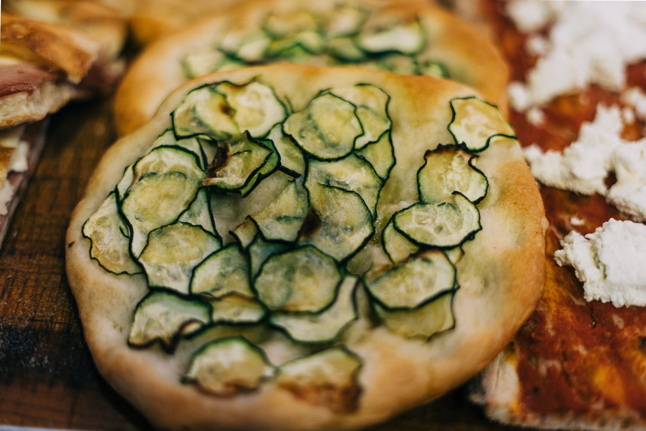 Eine runde Focaccia, belegt mit Zucchini