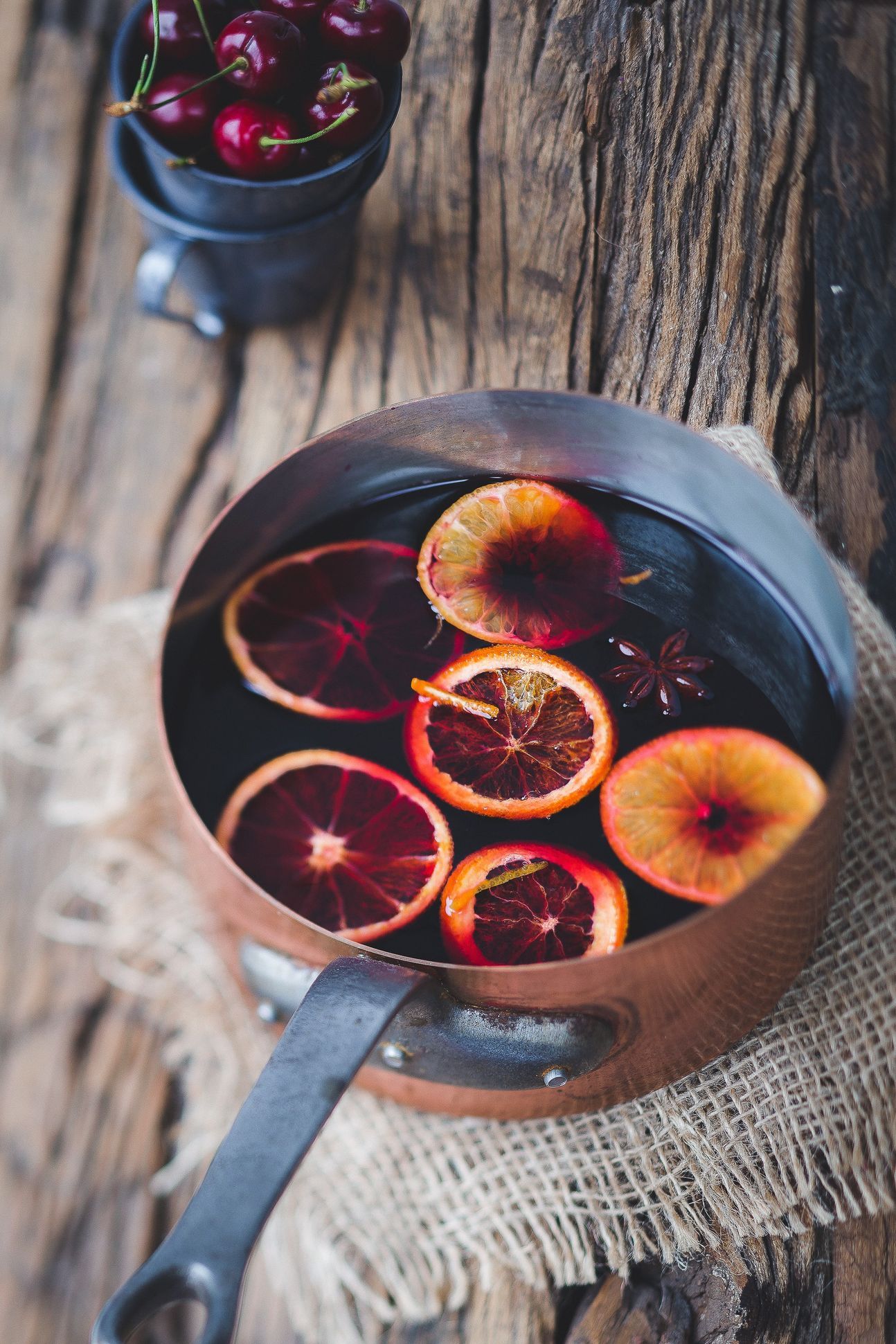 Eine Kupferpfanne mit Wein und Orangenscheiben.