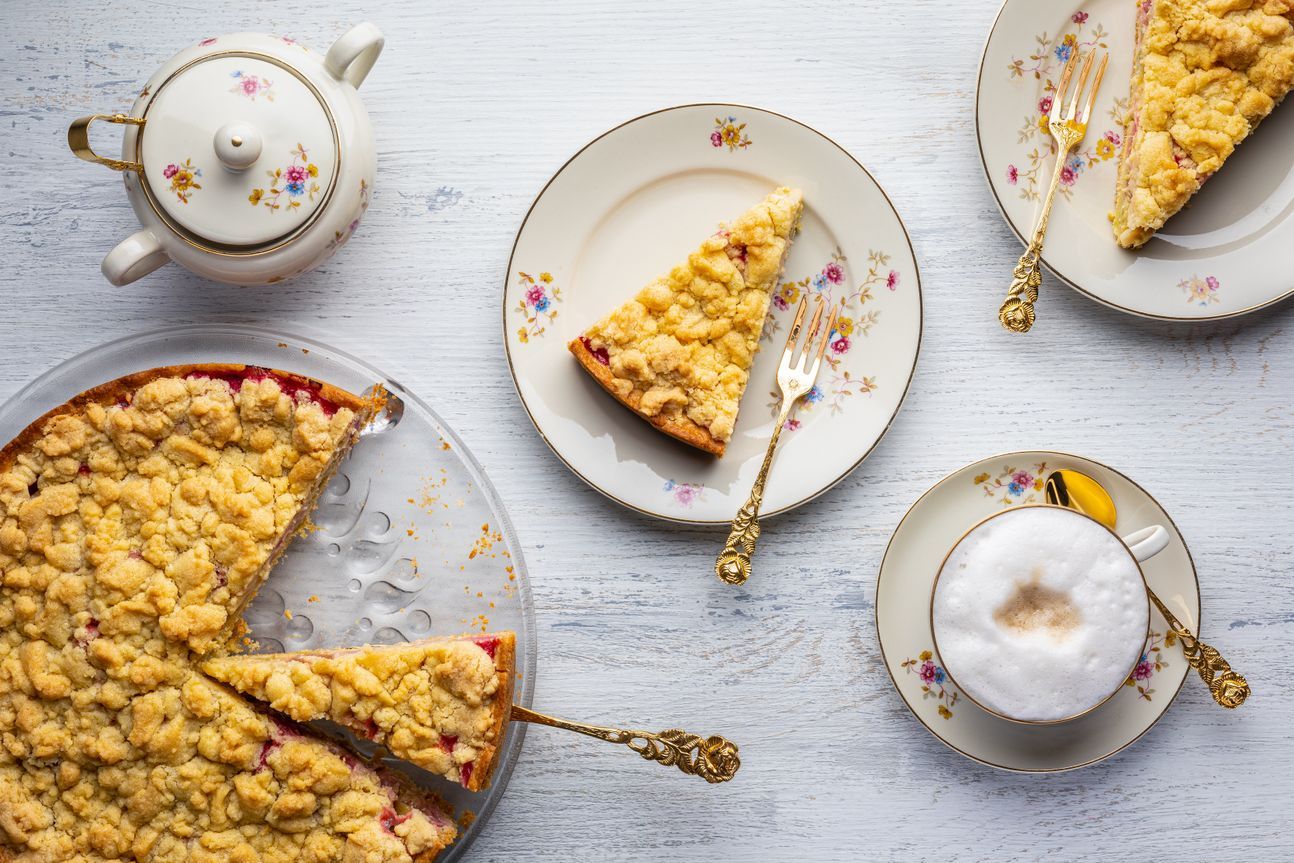 Streuselkuchen auf Tortenplatte und Desserttellern.