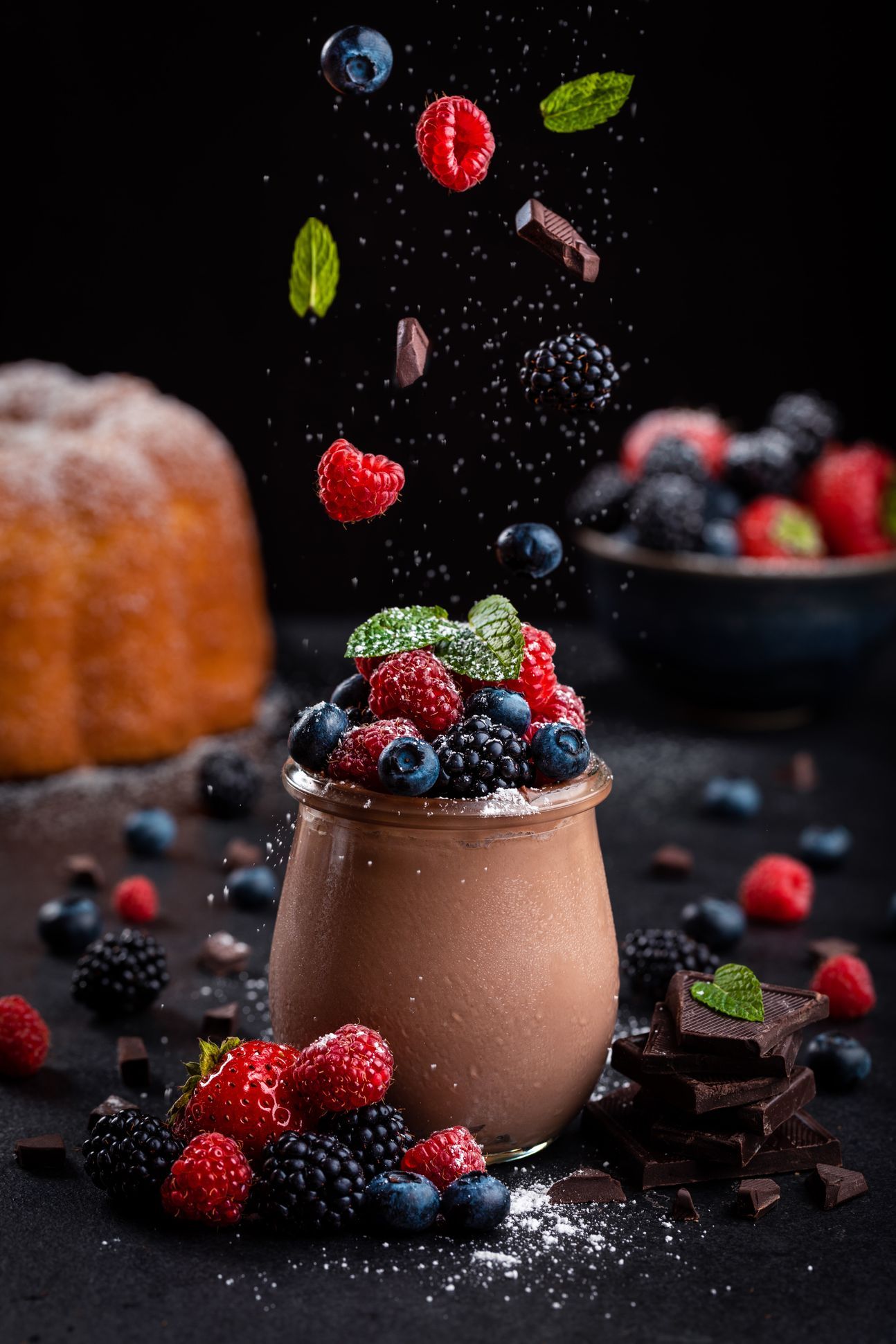 Ein Gläschen, gefüllt mit Schokokuchen, dekoriert mit vielen frischen Beeren.