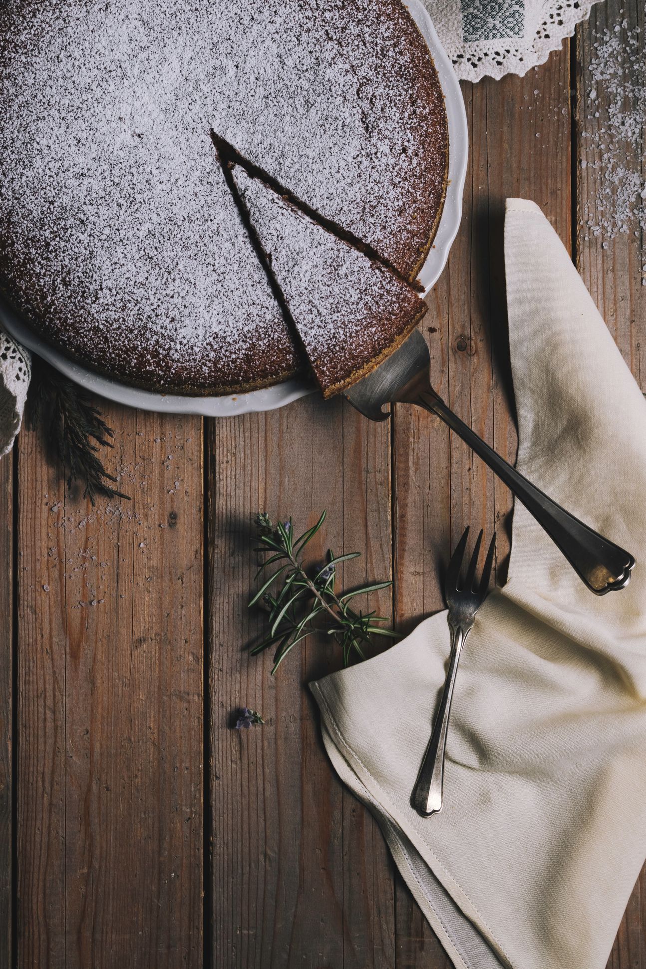 Ein runder Mandelkuchen, davon ein Stück geschnitten.