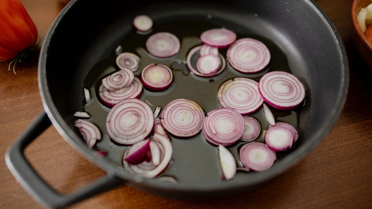 Pfanne mit Zwiebelscheiben in Öl.