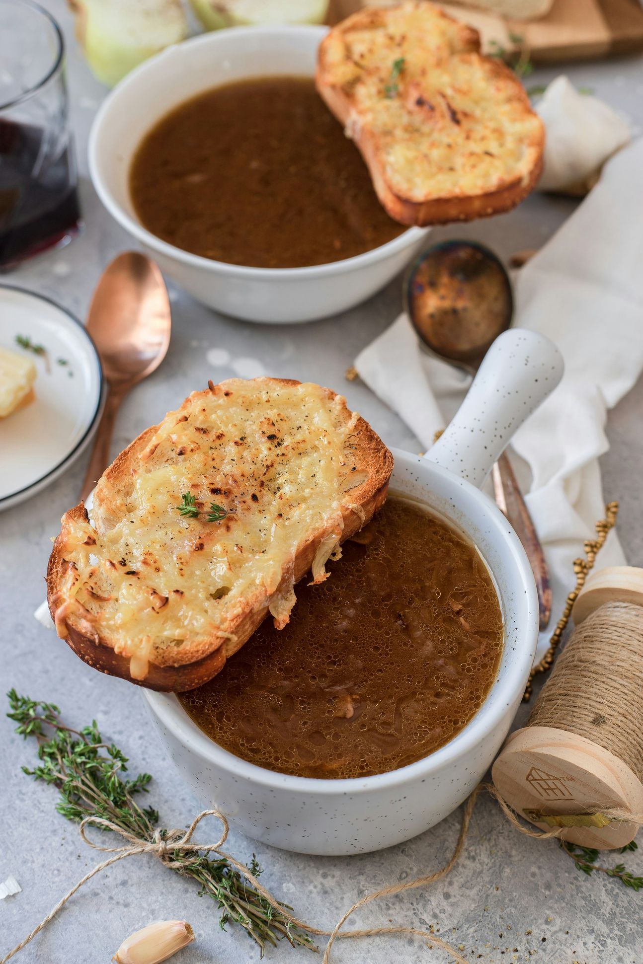 Zwiebelsuppe in zwei Suppenschalen mit Weißbrotscheiben